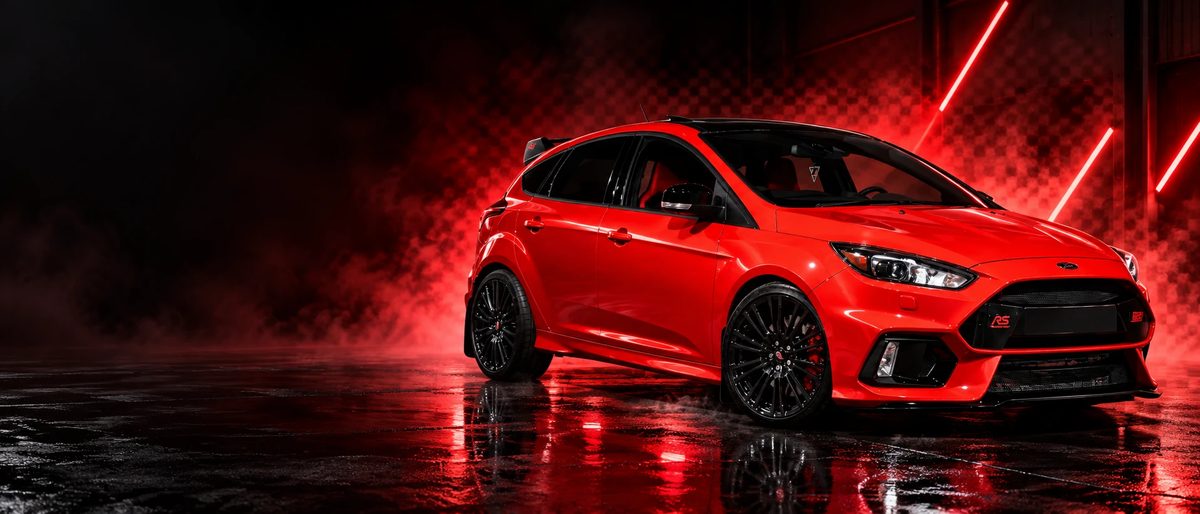 Червен Ford Focus RS с черни джанти в тъмна камера с червена светлина
